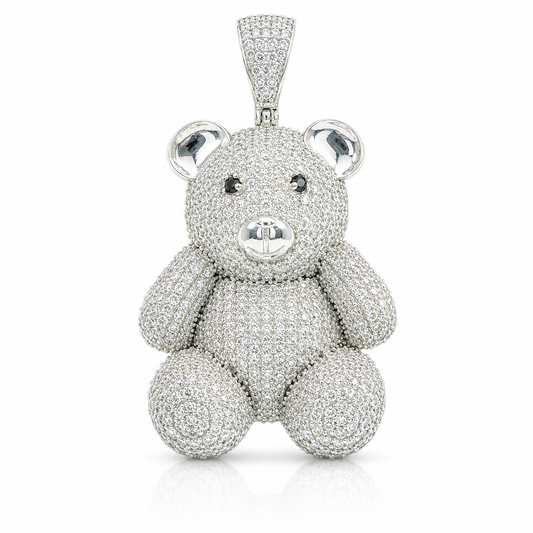 A teddy bear pendant encrusted with sparkling clear gemstones, set in a silver-toned metal and photographed against a clean white background.