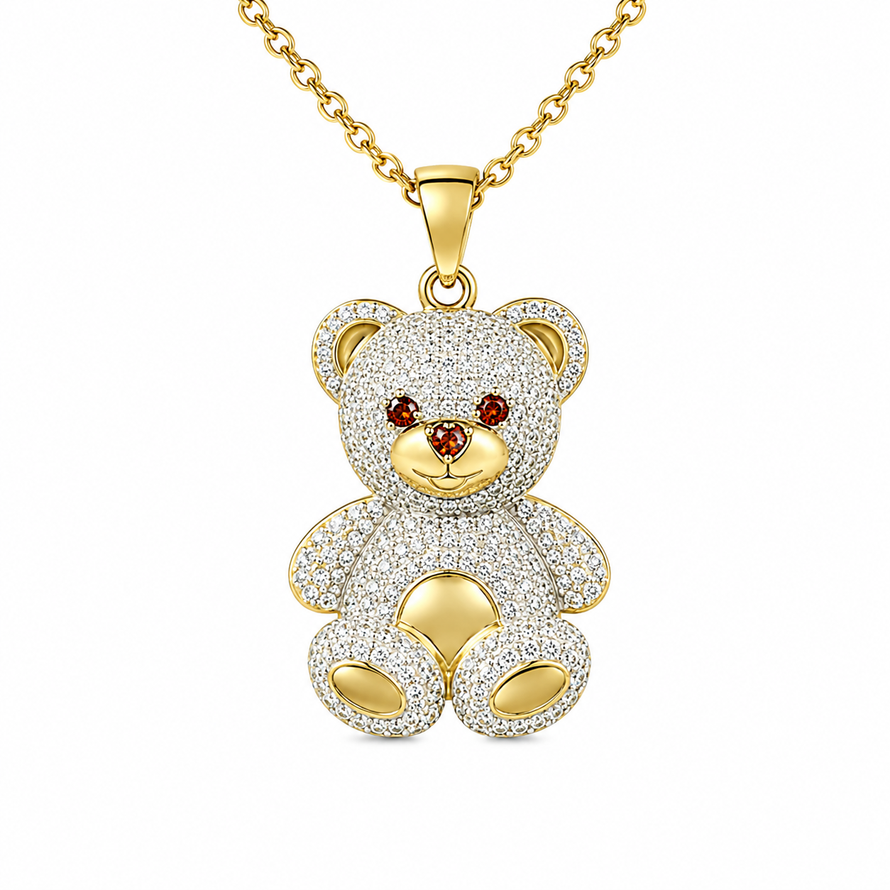 A gold-tone teddy bear pendant necklace encrusted with clear pavé stones, featuring small red gemstone eyes and a gold-tone chain, shown on a plain white background.