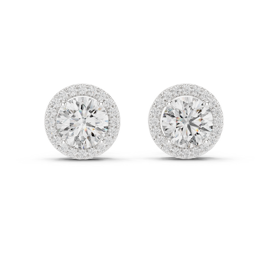 A pair of round halo stud earrings with brilliant-cut center stones surrounded by a halo of smaller stones, set in a silver-toned metal on a white background.